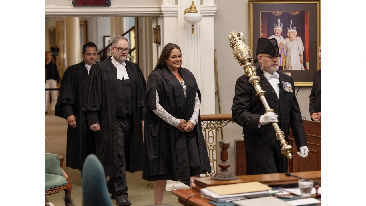 Photo of new Speaker Danielle Barkhouse being escorted in the legislative chamber