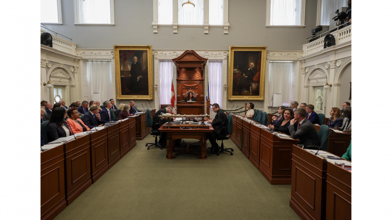 Photo of MLAs and new House Speaker Danielle Barkhouse in the legislative chamber