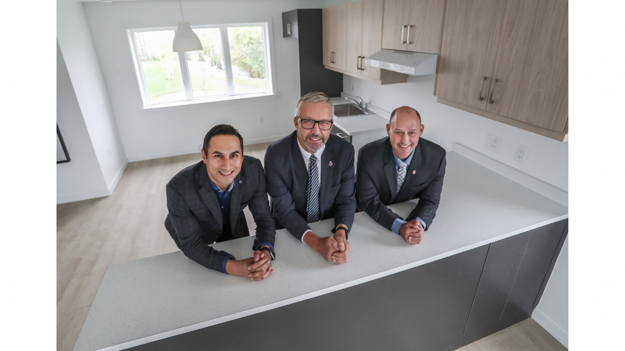 Michael Kabalen, Minister John Lohr and Minister Timothy Halman pose inside the kitchen Dartmouth announcement