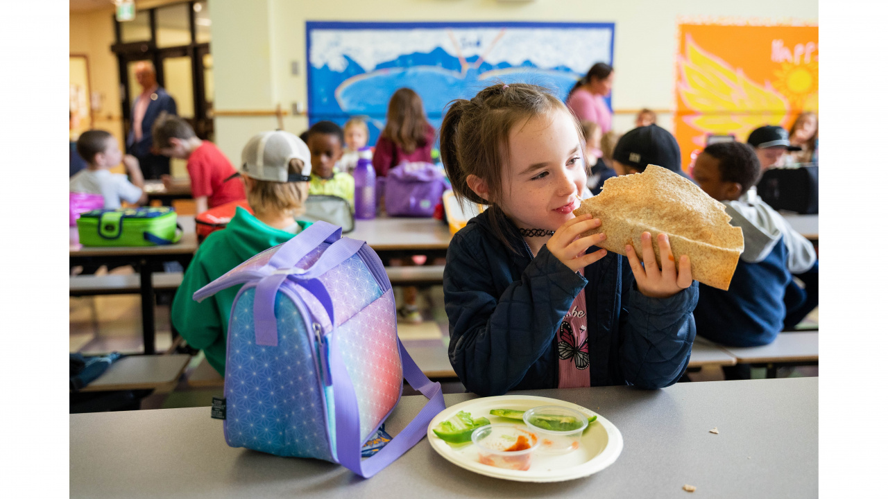 Photo of a girl eating a taco at school