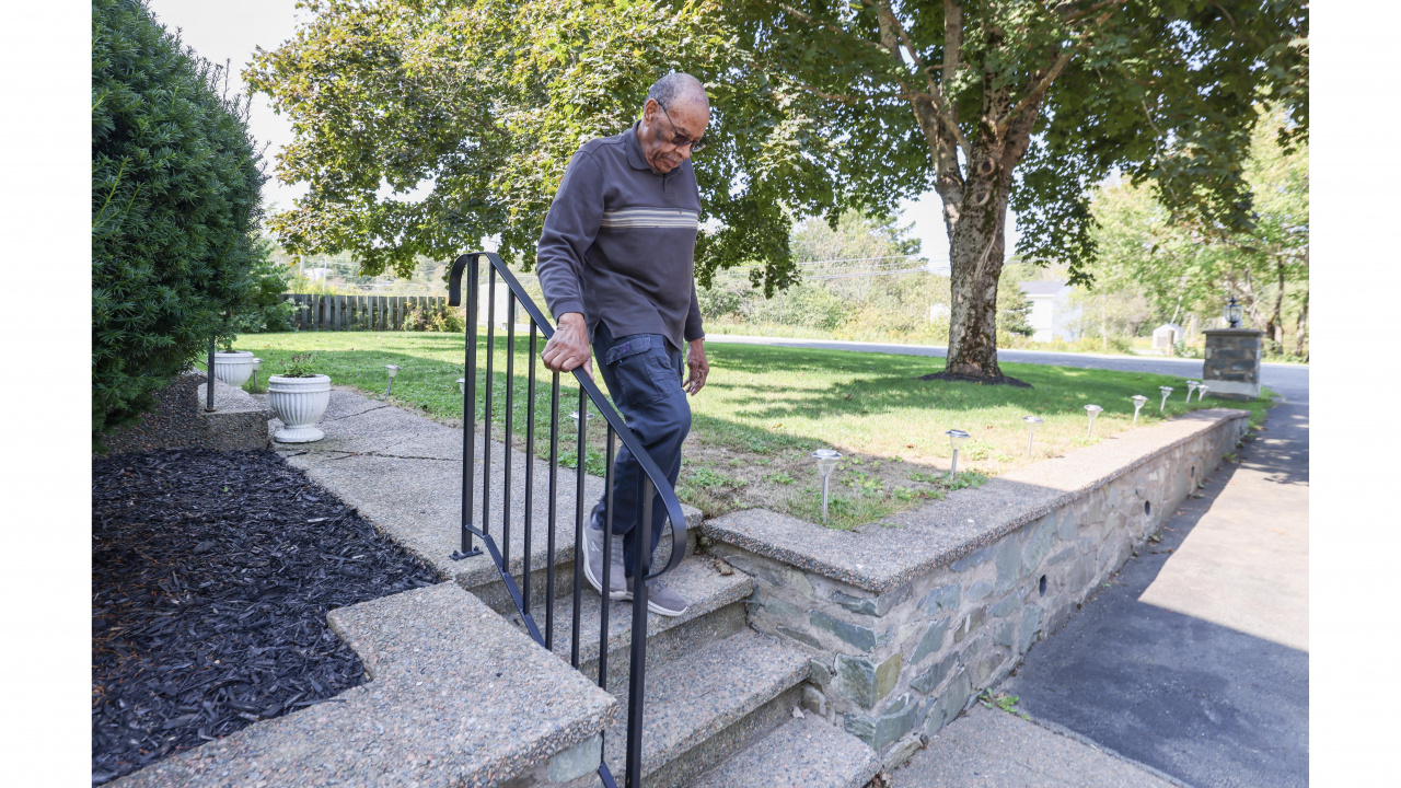 Photo of a man walking down stairs outside a home