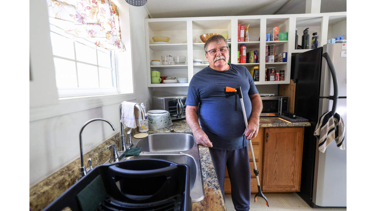 Photo of a man in a kitchen holding a grabber