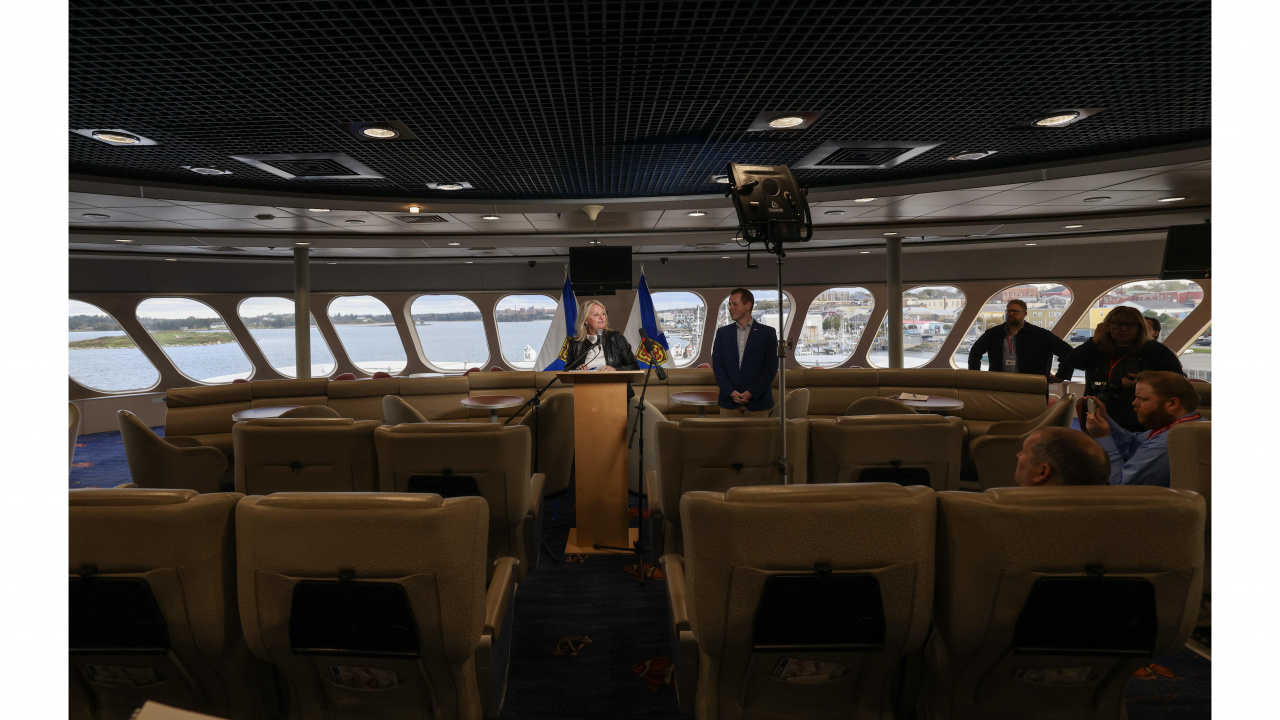 Photo of Public Works Minister Kim Masland standing at a podium aboard the Cat ferry, along with Service Nova Scotia Minister Colton LeBlanc