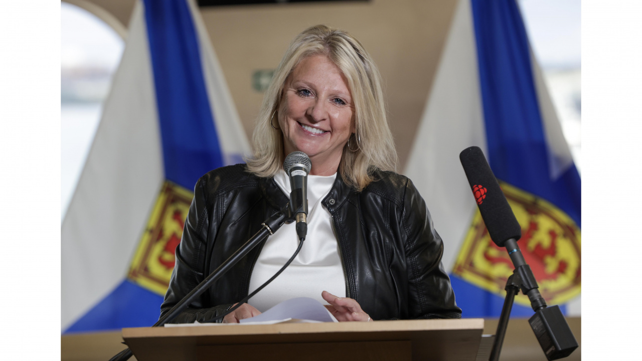 Public Works Minister Kim Masland stands at a podium 