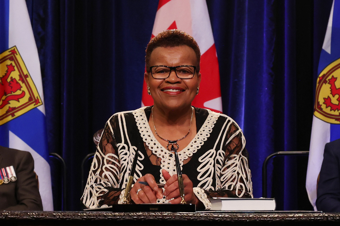 Photo of Minister Twila Grosse signing the oath of office document