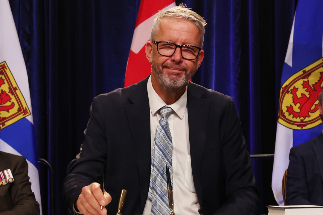 Photo of Minister John Lohr signing the oath of office document