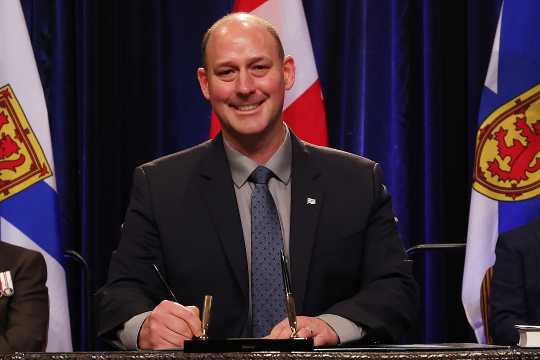 Photo of Minister Timothy Halman signing the oath of office document