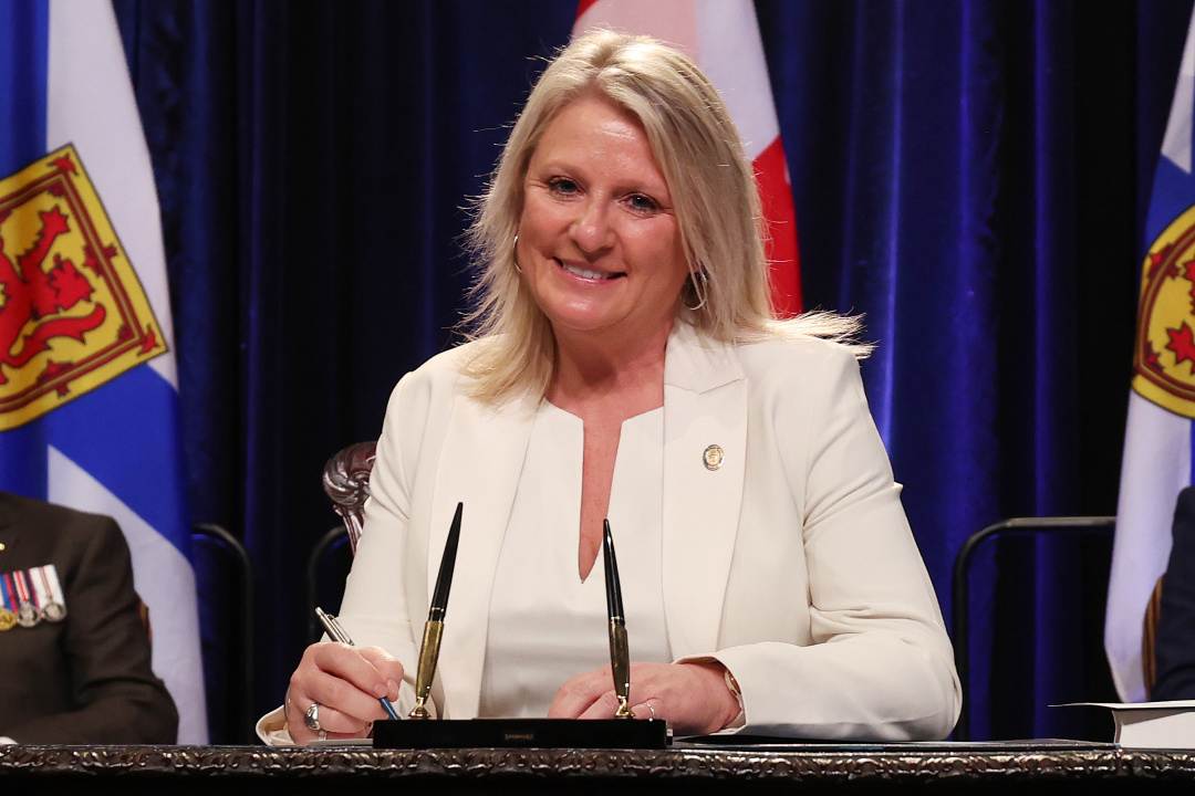 Photo of Minister Kim Masland signing the oath of office document