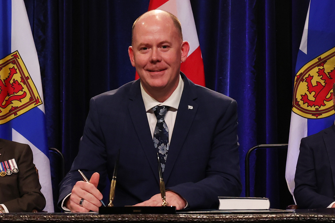 Photo of Minister Tory Rushton signing the oath of office document