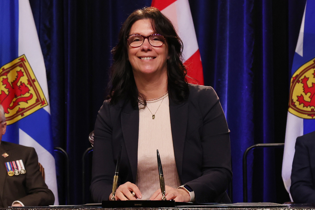 Photo of Minister Michelle Thompson signing the oath of office document