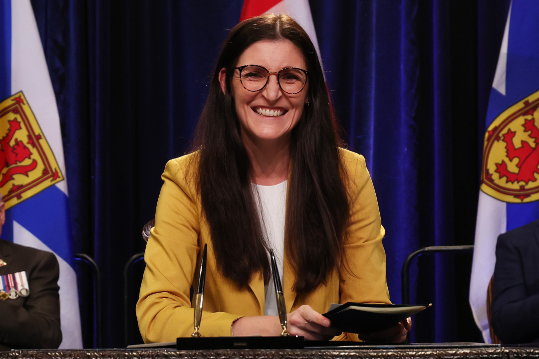 Photo of Minister Jill Balser signing the oath of office document