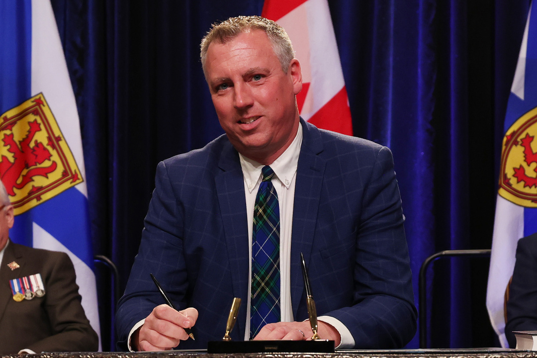 Photo of Minister Greg Morrow signing the oath of office document