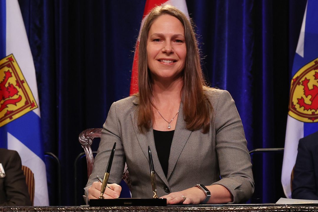 Photo of Minister Becky Druhan signing the oath of office document