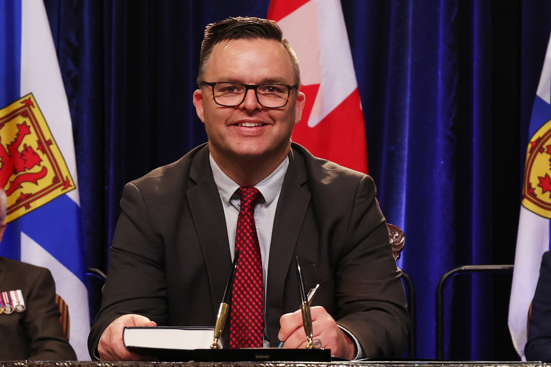 Photo of Minister Brendan Maguire signing the oath of office document