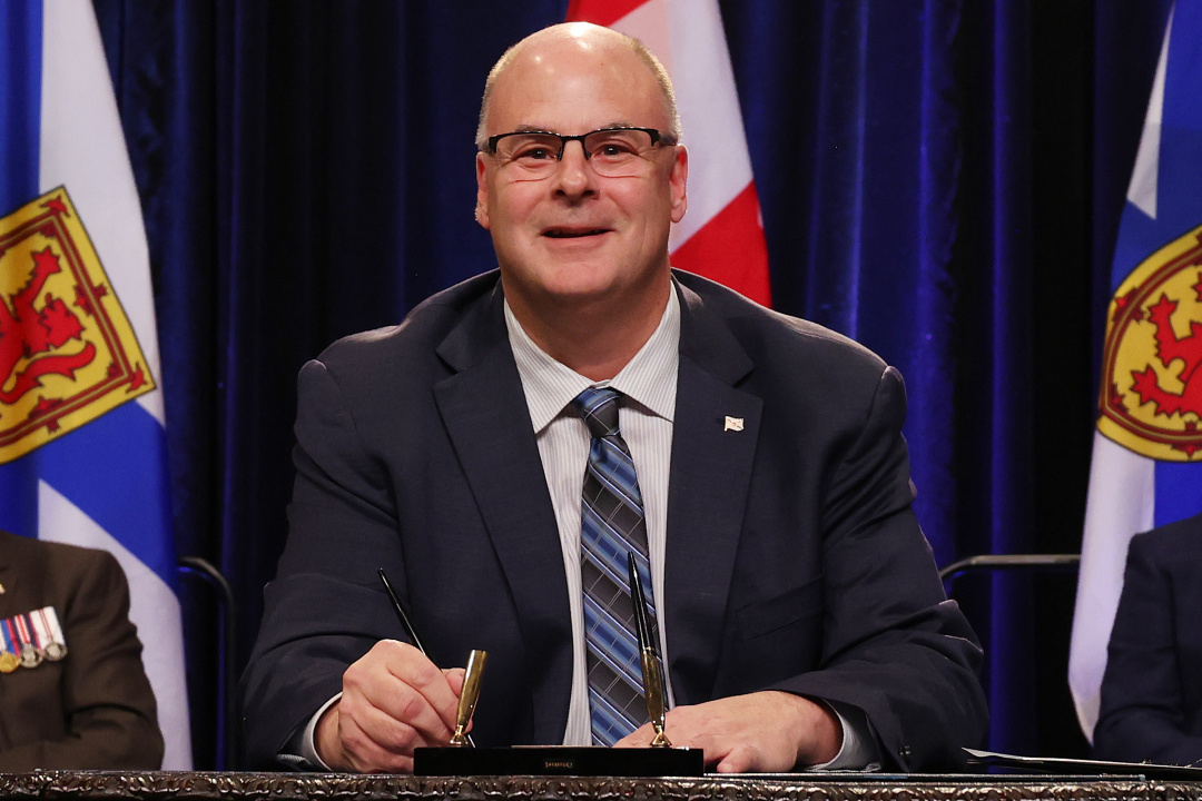 Photo of Minister David Ritcey signing the oath of office document