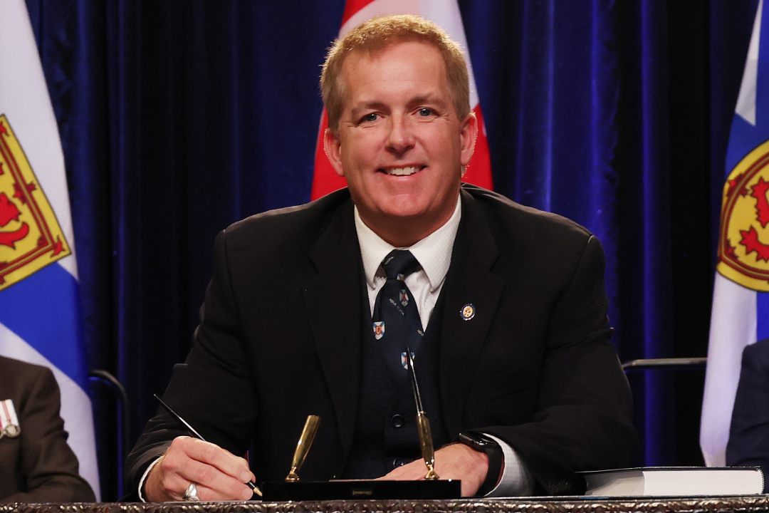 Photo of Minister Scott Armstrong signing the oath of office document