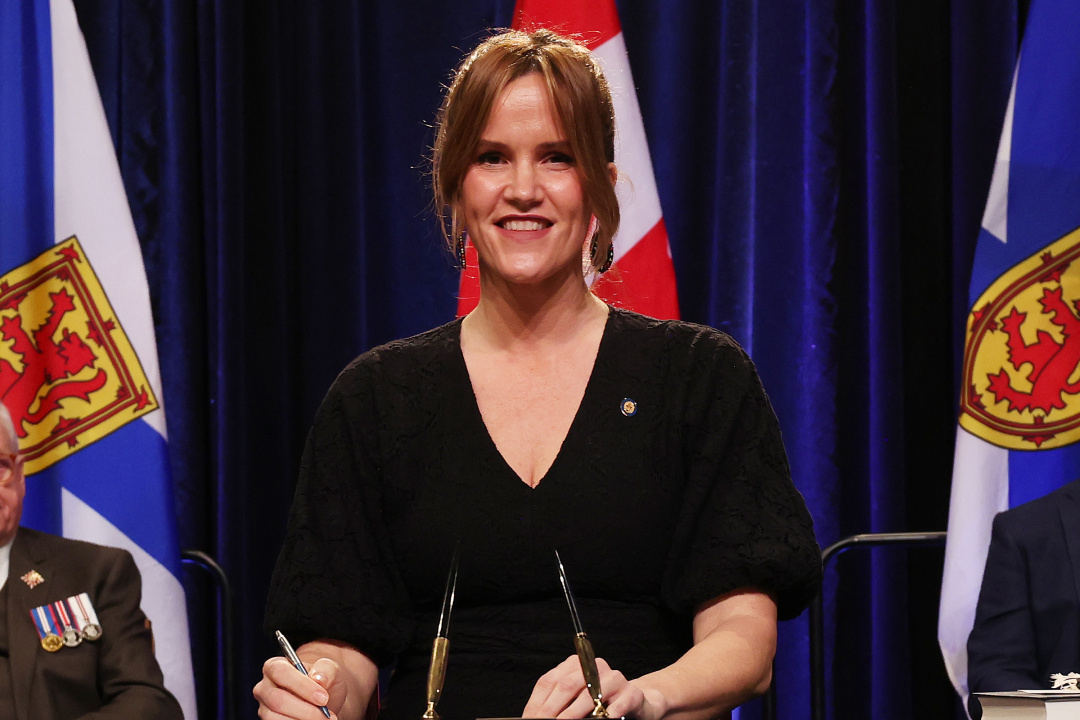 Photo of Minister Leah Martin signing the oath of office document