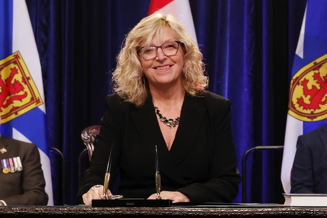 Photo of Minister Barbara Adams signing the oath of office document