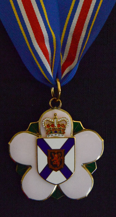 The Order of Nova Scotia medal in the form of a stylized mayflower, the provincial floral emblem, bearing the shield of arms of Nova Scotia with the crown above