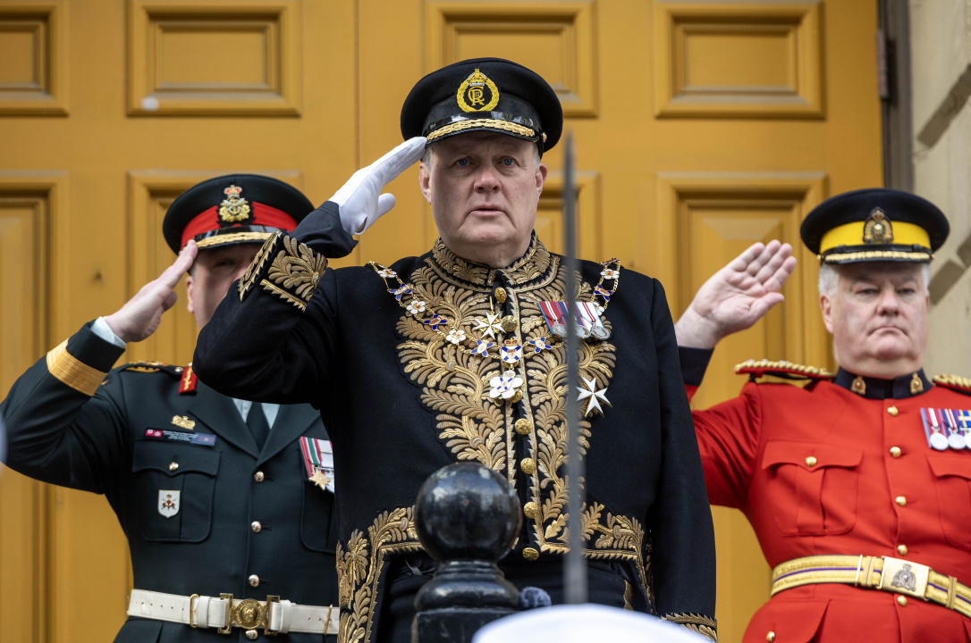 Lt.-Gov. Mike Savage salutes an honour guard