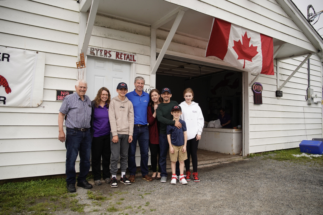 Premier Tim Houston with the Ryer family standing outside a building