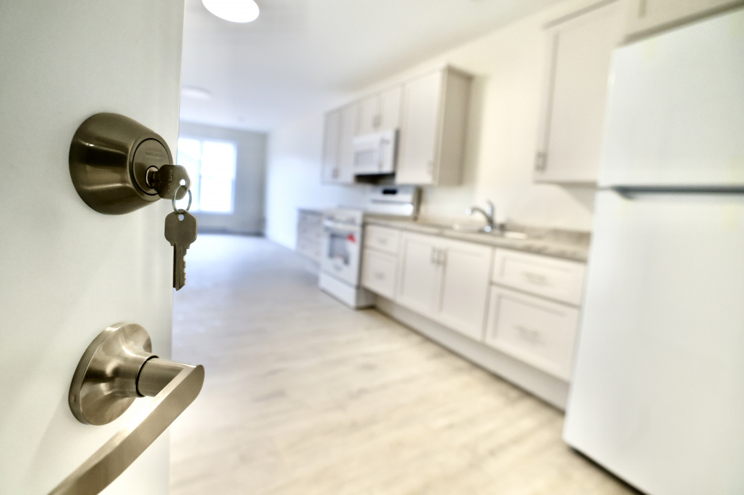 Looking into a kitchen with key in a door lock in the foreground