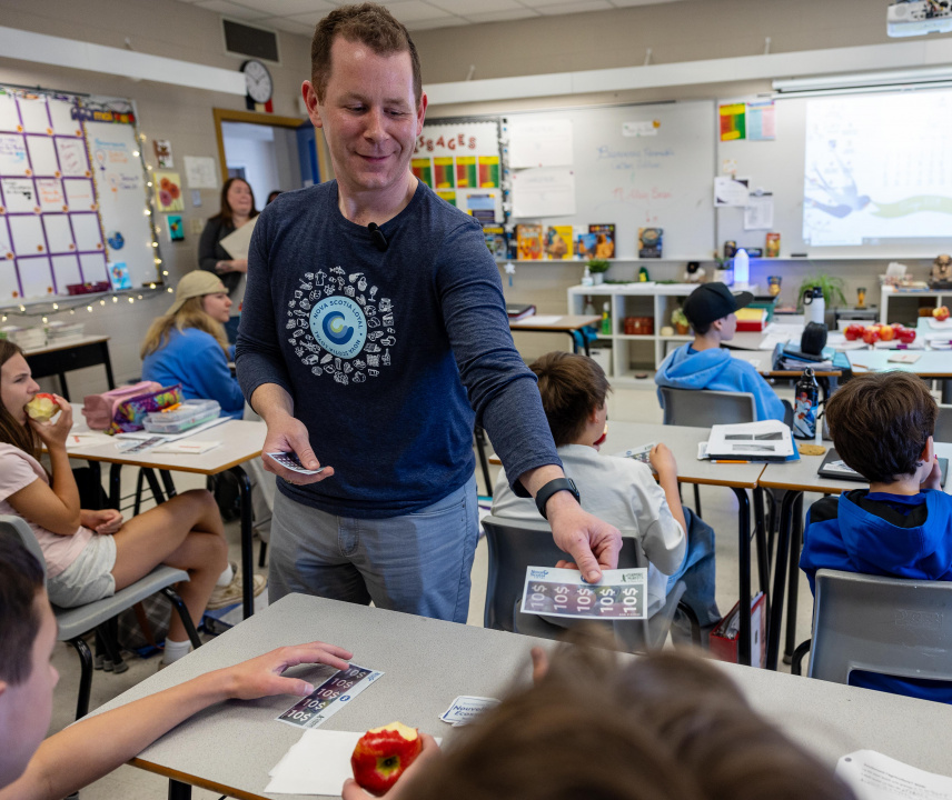 Growth and Development Minister Colton LeBlanc hands out vouchers in a classroom