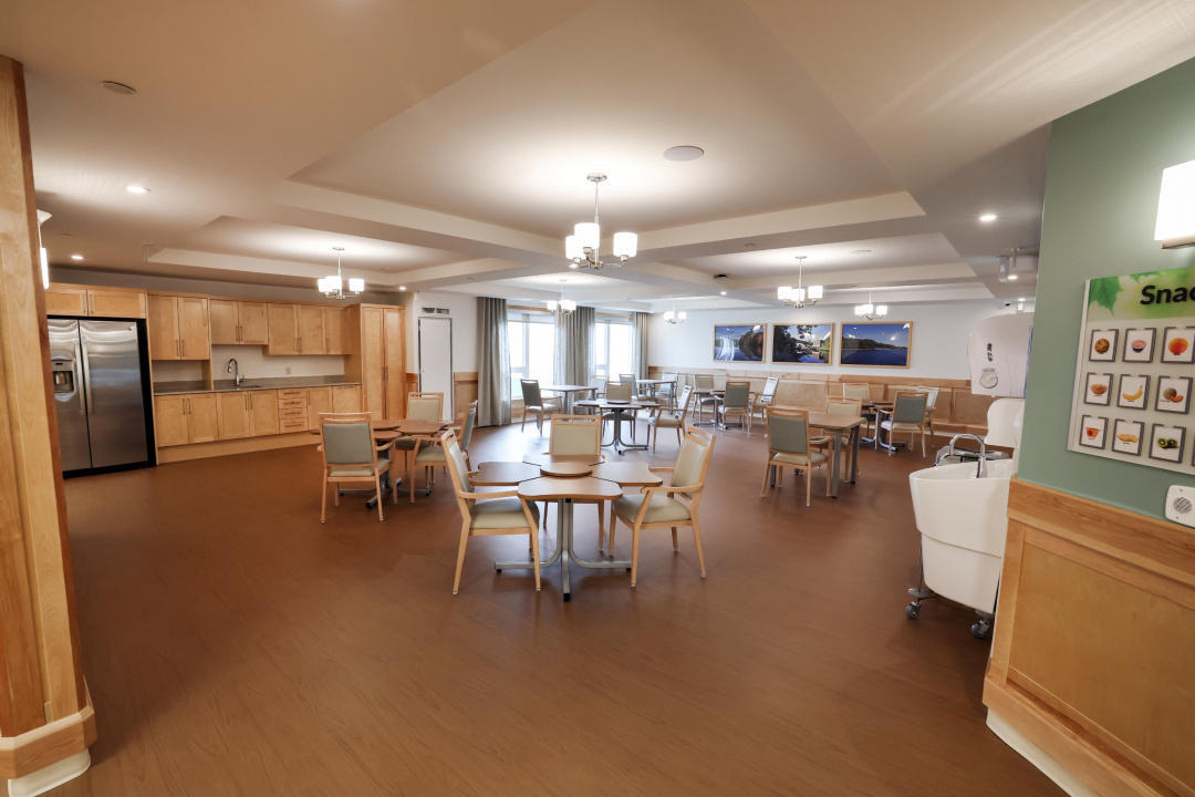 Dining tables and a kitchen area at a new long-term care home