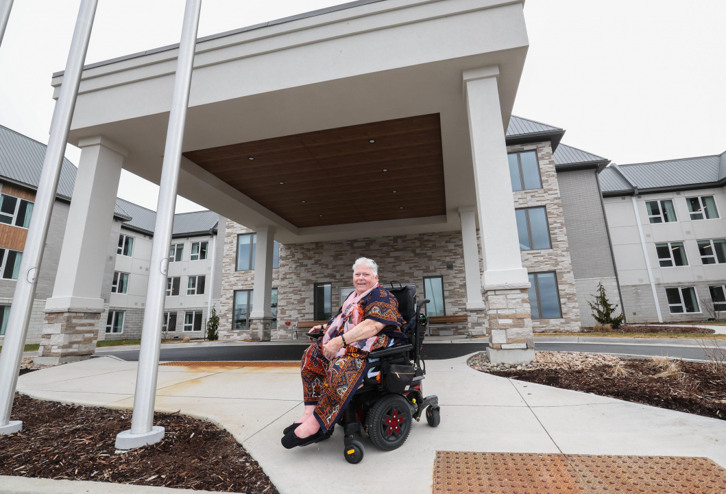 A woman in a wheelchair outside a new long-term care home
