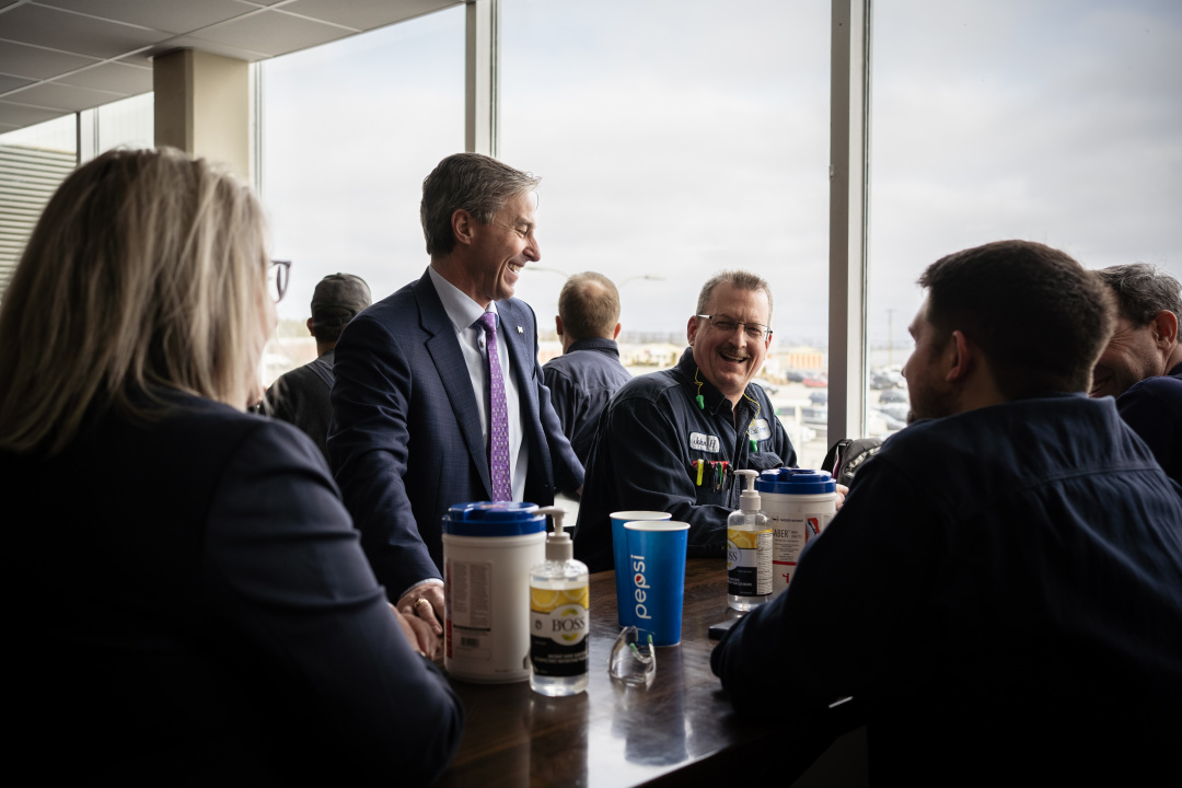 Premier Tim Houston (centre) talks with workers at the Michelin plant in Bridgewater during a tour of the facility in 2023