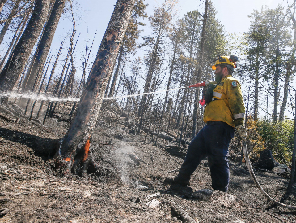 Department of Natural Resources staff member Mark Shaw fighting a fire.