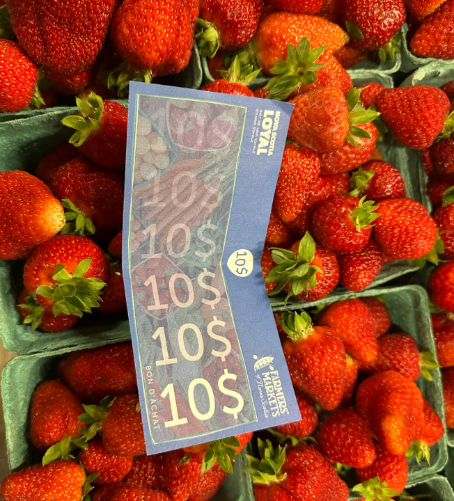 Un bon de Nova Scotia Loyal placé sur des boîtes de fraises.