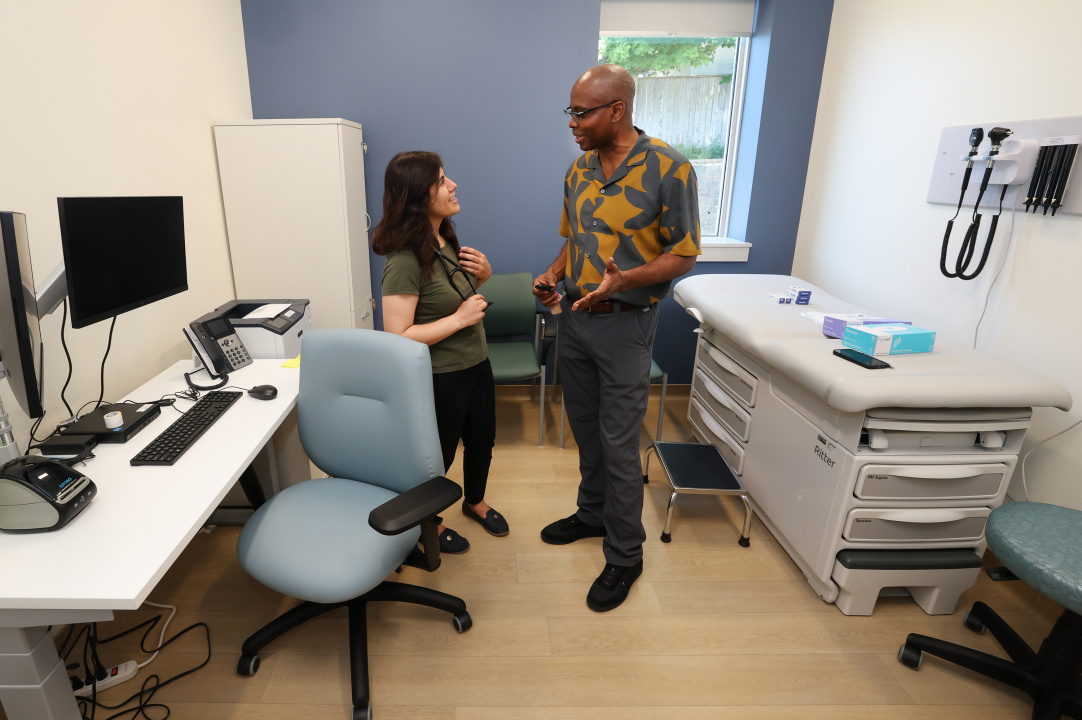 Two family doctors talking in a clinic exam room