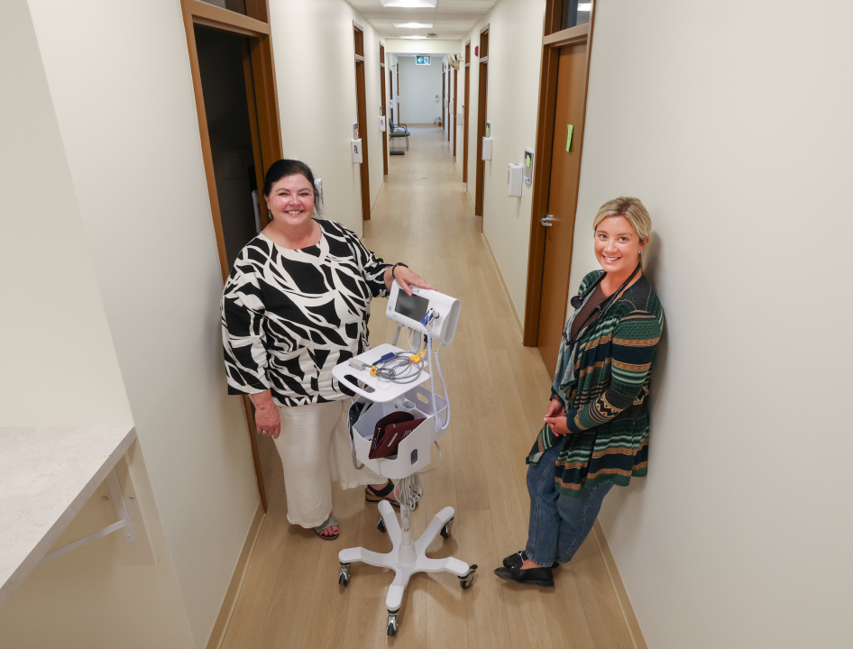 A family practice nurse and a nurse practitioner in the hallway of a health clinic