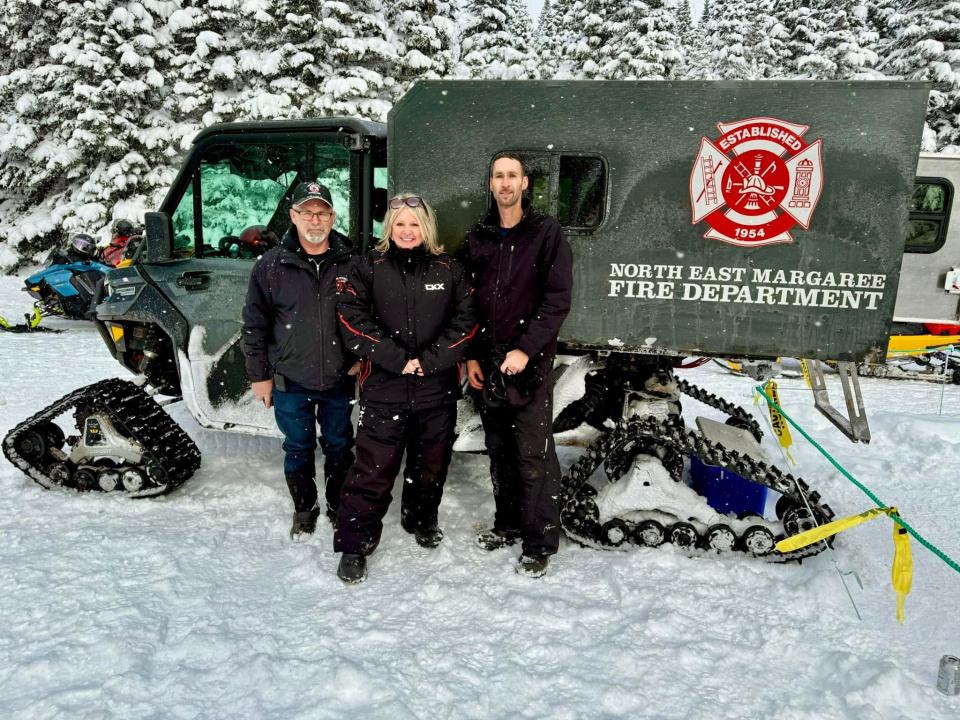 Emergency Management Minister Kim Masland with Leonard Ross, left, and Kevin Curley of the Northeast Margaree Fire Department in front of the department’s off-road rescue vehicle.