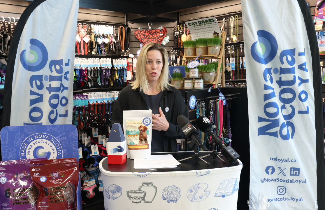 Julie Houde, sales and marketing agent, Ocean Pride Fisheries, at a Nova Scotia Loyal podium in a specialty pet store