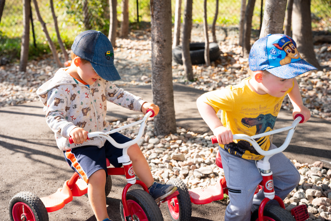 Deux enfants faisant du tricycle.