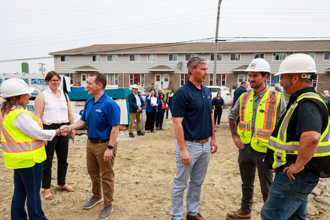 Premier Tim Houston speaks to construction workers at a housing site