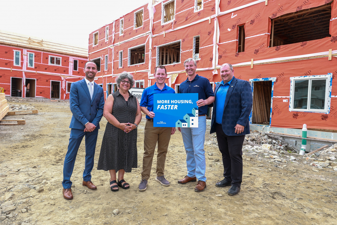 Premier Tim Houston and others at a construction site holding a sign