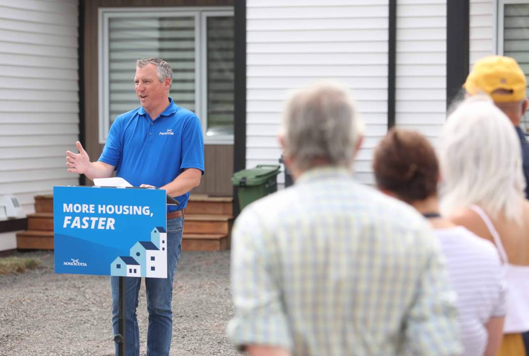 Agriculture Minister Greg Morrow outside a housing unit during an announcement