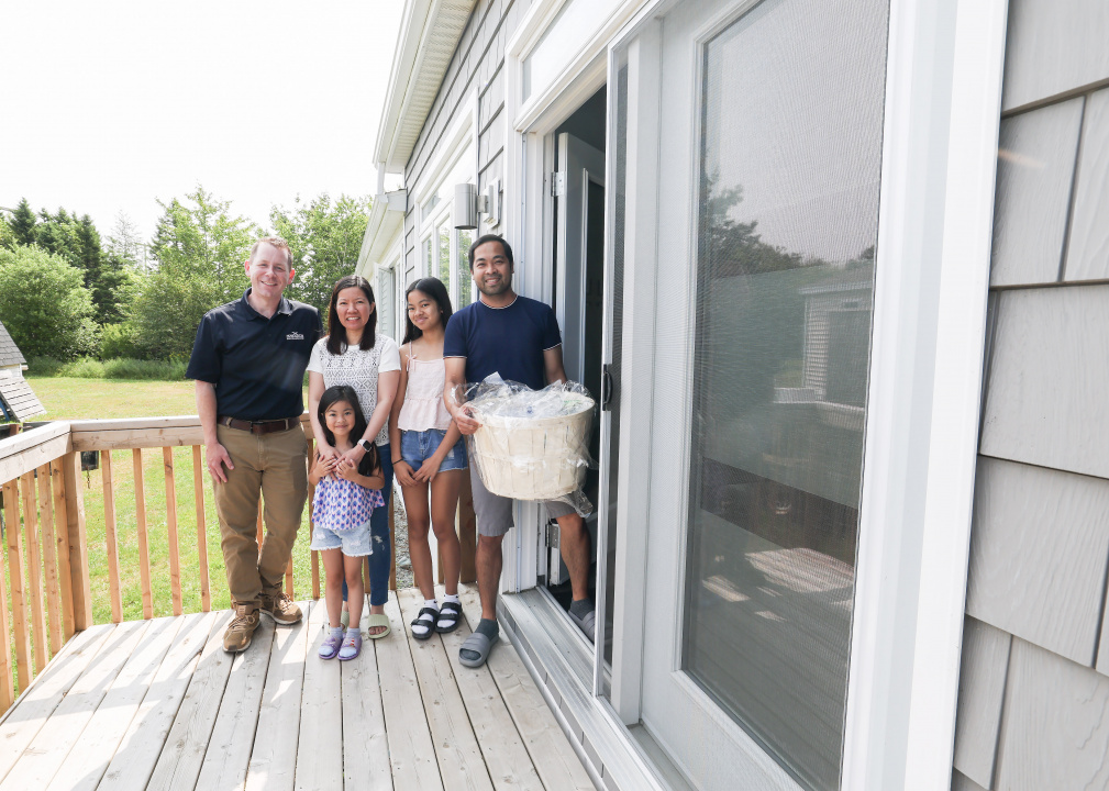 Growth and Development Minister Colton LeBlanc with a family on their deck