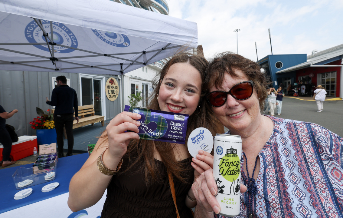 Two women holding up Nova Scotia Loyal products