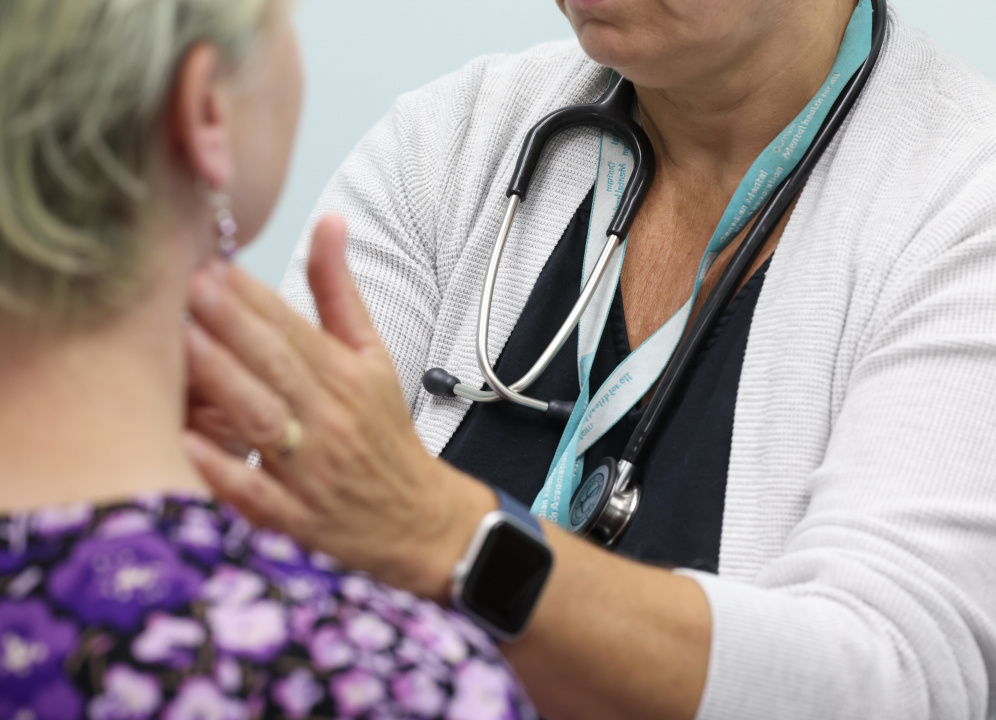 A healthcare professional examines a patient.