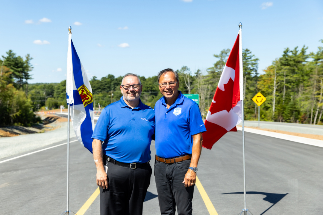 (left to right) Fred Tilley, Minister of Public Works, and Brian Wong, MLA for Waverley-Fall River-Beaver Bank stand on the road in front of flags at the opening of the Aerotech Connector.