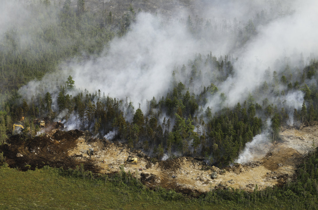 Crews work with heavy equipment to create a fire break around part of the Long Lake wildfires complex. 