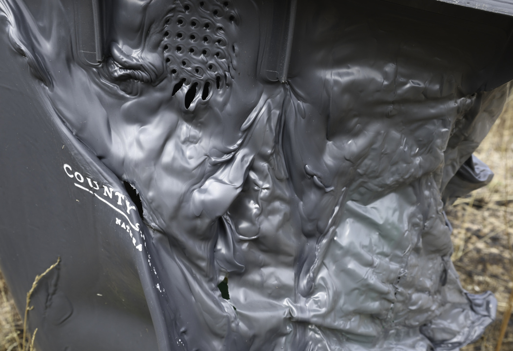 A compost bin melted by fire