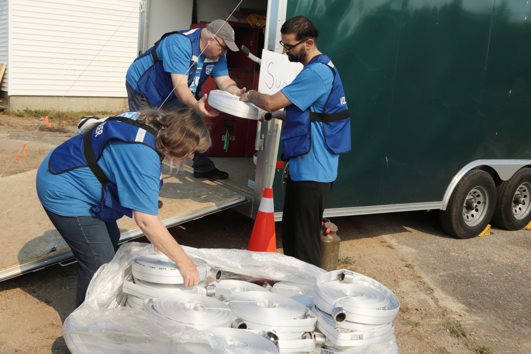 Nova Scotia Guard members move new fire hoses into a trailer at the West Dalhousie Community Centre.