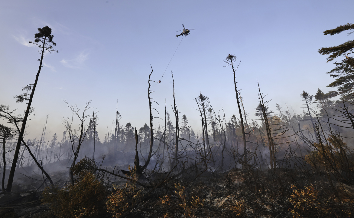 A helicopter drops water on the wildfire.