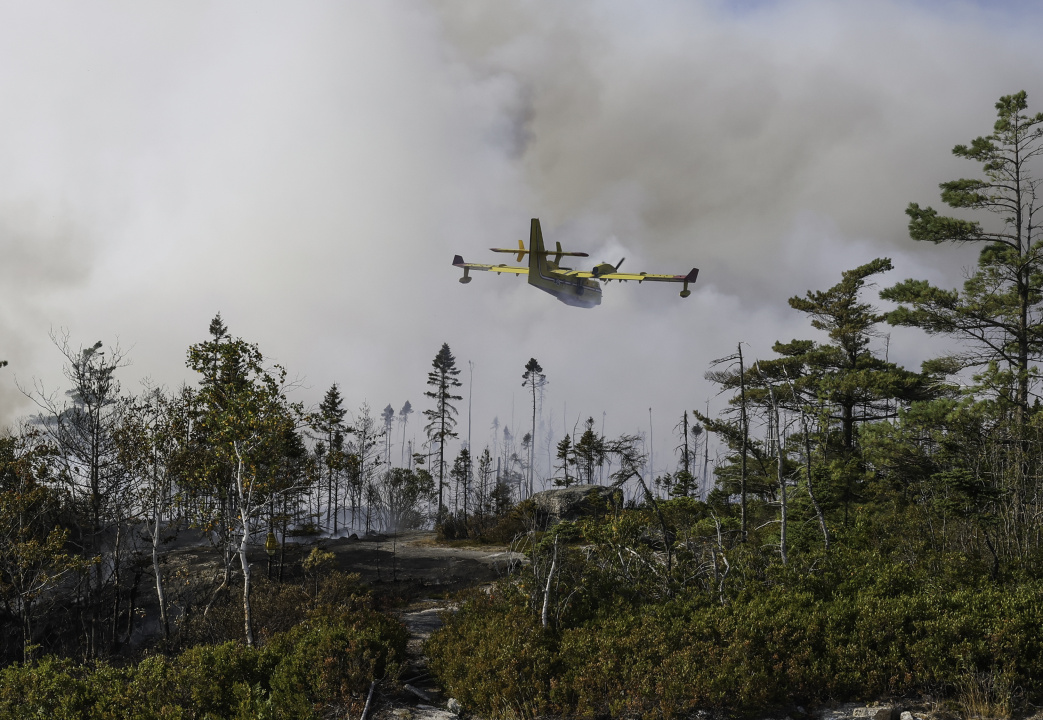 A water bomber make a pass over wildfire.