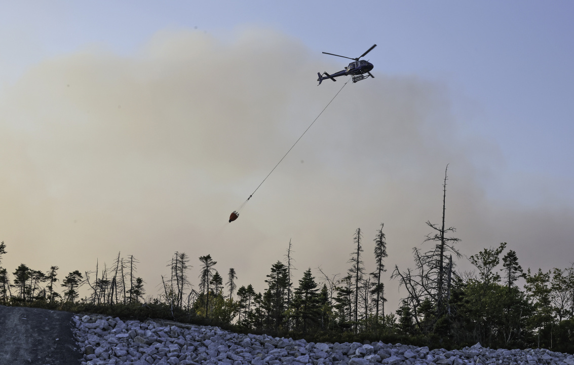 A helictoper drops water on the wildfire.
